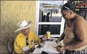 ?? TAMMY JOYNER / TJOYNER@AJC.COM ?? Chuck Ware registers Clayton County resident Darlean Bannister Oliver as a new voter in Georgia Thursday at the Walmart in Lovejoy. He says having to repeatedly return to the elections office to replenish applicatio­ns is annoying.