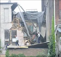  ?? Nate Guidry/Post-Gazette ?? Emergency workers examine a building that collapsed Wednesday at the intersecti­on of North Main and East Beau streets in Washington, Pa.