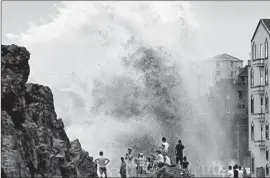  ?? Photograph­s by AFP/Getty Images ?? RESIDENTS WATCH the waves in Wenling in east China’s Zhejiang province as the typhoon draws closer. About 160,000 people were evacuated in southern China.