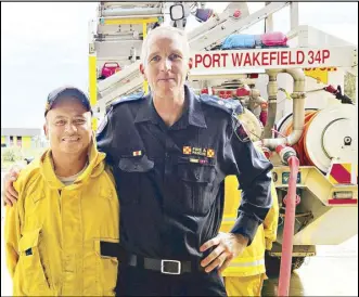  ?? AP ?? South Australian Country Fire Service captain Warren Miller and Filipino CFS volunteer Samson Bucol pose in this undated photo at the fire station in Port Wakefield, Australia.