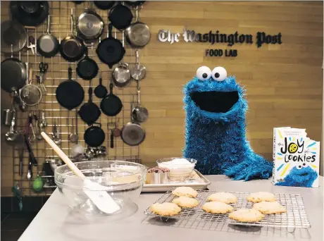  ?? SARAH L. VOISIN/THE WASHINGTON POST ?? Cookie Monster oversees a batch of every-monster cookies from his new book, The Joy of Cookies. These ones featured white chocolate chips. And yes, there is a bite taken out of every book.