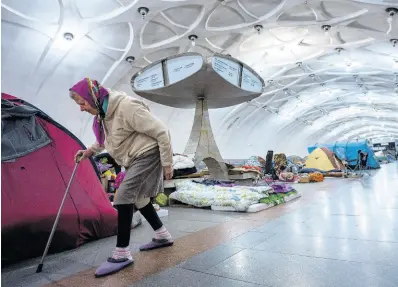  ?? AP ?? An elderly woman walks inside a metro station being used as a bomb shelter in Kharkiv, Ukraine, yesterday.