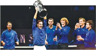  ?? AFP ?? ROGER FEDERER of Team Europe and his teammates celebrate with the Laver Cup trophy on Sept. 24 in O2 Arena, in Prague.