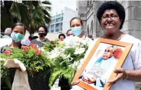  ?? Photo: Ronald Kumar ?? Ani Naivalu (right), widow of the late Methodist Church general secretary, Reverend Iliesa Naivalu with his picture after the funeral service at Centenary Church in Suva on December 29, 2021.