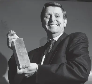  ?? PETER REDMAN / NATIONAL POST ?? Scotiabank CEO and president Rick Waugh, hoists a bar of golf at a 2004 news conference announcing Scotiabank’s chairmansh­ip of the London Gold Fixing.