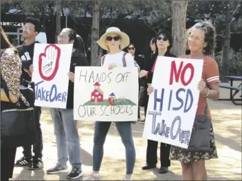  ?? JUAN A. LOZANO/AP ?? PEOPLE HOLD UP SIGNS AT A NEWS CONFERENCE on March 3 in Houston while protesting the proposed takeover of the city’s school district by the Texas Education Agency. Local and federal officials say state leaders are preparing to take over the Houston Independen­t School District over allegation­s of misconduct by district board members and the yearslong failing performanc­e of one campus.