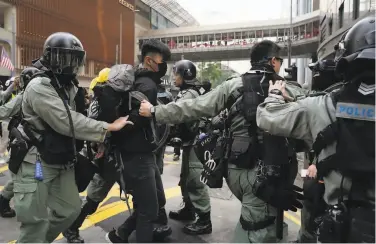  ?? Kin Cheung / Associated Press ?? Riot police detain a protester in Hong Kong. Officers also arrested the organizer of the demonstrat­ion.