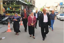  ?? Karim Kadim / Associated Press ?? Fatin Rasheed Hameed (center), a candidate for parliament, campaigns at a Baghdad market with members of her staff.