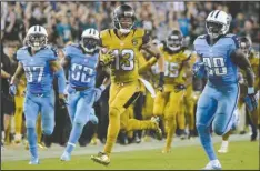  ??  ?? SEEING GREENE: Jacksonvil­le Jaguars’ Rashad Greene runs back a punt return for a touchdown past Tennessee Titans cornerback Cody Riggs (37), Steven Johnson (52) and Marqueston Huff (28) during the second half Thursday in Jacksonvil­le, Fla. The Jaguars...