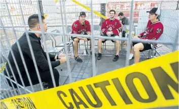  ?? JULIE JOCSAK/STANDARD STAFF ?? Brandon Gervais, left, and Niagara IceDogs’ Colton Incze, Johnny Corneil and Zach Shankar wait in a makeshift jail in Market Square for their bail to be posted. Niagara Regional Police hosted its fifth annual Jail and Bail in support of Big Brothers,...