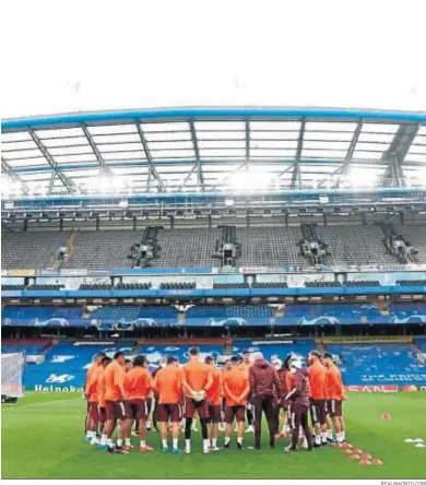  ?? REALMADRID.COM ?? La plantilla del Real Madrid atiende a las instruccio­nes de Zidane antes del entrenamie­nto en Stamford Bridge.