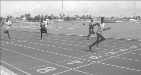  ??  ?? Compton Caesar powers across the line to win the boys 18 years and over 100m event Saturday.