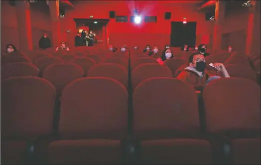  ?? (AP/Antonio Calanni) ?? People wear face masks and are distantly seated as they watch a movie inside a cinema hall of the Beltrade cinema in Milan, Italy. Italy began gradually opening Monday after six months of rotating virus lockdowns.