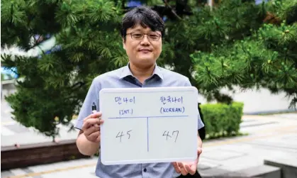  ?? Photograph: Anthony Wallace/AFP/Getty Images ?? ‘South Korea’s government has given its citizens the gift of youth.’ Hong Suk-min poses with a whiteboard showing his internatio­nal age (45) and his Korean age (47).