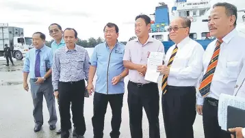  ??  ?? Uggah (second right) and Dr Ng hold up an Export License and Veterinary Health Certificat­e issued by the State Veterinary Authority for the import of the livestock.