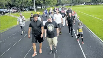  ?? JOHN LAW / NIAGARA FALLS REVIEW ?? Cancer survivor Karter Ellis, front, right, walks alongside former CFL placekicke­r Dan Giancola during Saturday's 7th annual Heater's Heroes at Oakes Park.