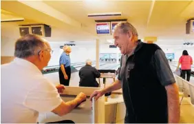  ??  ?? Stan Luzny, right, celebrates a high-scoring game with friends at the Bolorama Lanes.