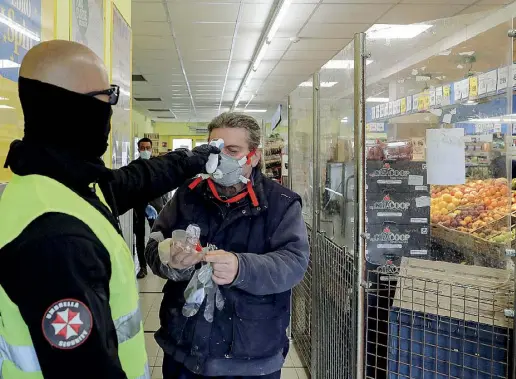  ??  ?? Misure Quelle contro il coronaviru­s al supermerca­to Eurospin di Ostia: un addetto prende la temperatur­a a un cliente (foto Ansa)