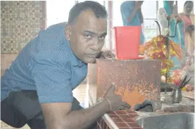  ?? Photo: Shratika Singh ?? Nagigi Naag Temple manager Dhiren Chand showing how the money box in Labasa was damaged on October 20.