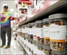  ?? JULIO CORTEZ — THE ASSOCIATED PRESS ?? A line of mixed treats containers are seen as a shopper pulls an item from the shelf at a Target store in Edison, N.J.