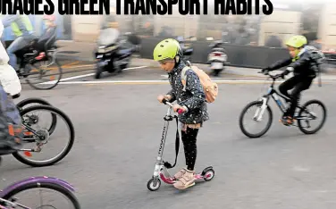  ?? —PHOTOS BY REUTERS ?? EASY RIDER Kids ride their bicycles to school on car-free streets as part of the city’s “bicibus” (bike bus) in Barcelona, Spain, on Nov. 23.