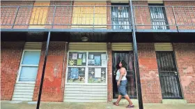  ?? JIM WEBER/THE COMMERCIAL APPEAL ?? Jessica Johnson-Peterson, president of the Renters Associatio­n at the Warren Apartments off Elvis Presley Boulevard, knocks on the door at the Global Ministries Foundation’s office at the apartment complex on May 10, 2016. The Warren complex is...