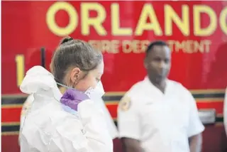  ?? RICARDO RAMIREZ BUXEDA/ORLANDO SENTINEL ?? Firefighte­r/paramedic Catherine Recicar demonstrat­es the protective items and procedures the Orlando Fire Department uses to deal with infectious diseases Monday.