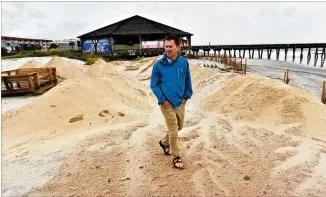  ?? HYOSUB SHIN / HYOSUB.SHIN@AJC.COM ?? Tybee Island Mayor Jason Buelterman walks on a sand dune the city built in preparatio­n for Hurricane Dorian, which spared the coastal Georgia city from serious damage.