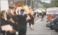  ??  ?? Protesters chant slogans while marching down the Post Road in Fairfield on Tuesday.