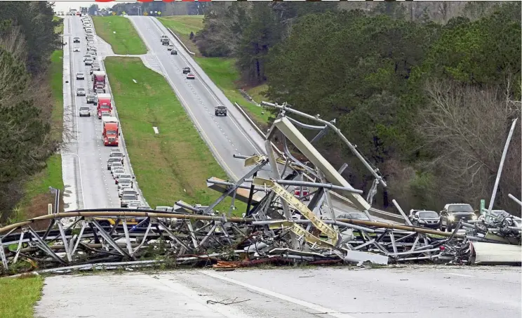  ?? — AP ?? Huge obstructio­n: A fallen cell tower blocking part of the US Route 280 highway in Lee County, Alabama, in the Smiths Station community after a tornado struck in the area. Strong storms destroyed mobile homes, snapped trees and left a trail of destructio­n amid weather warnings extending into Georgia, Florida and South Carolina.