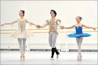  ??  ?? Eleven-year-old cancer survivor Charlie Tait, right, achieves her dream of dancing with stars of The Royal Ballet’s The Nutcracker, Yuhui Choe, left, and Benjamin Ella