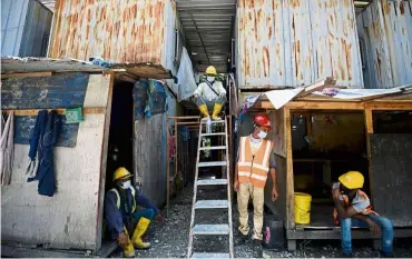  ??  ?? Staying safe: Foreign workers maintainin­g social distancing in a ‘rumah kongsi’ at a constructi­on site in Kuala Lumpur. Soon (below) observing a worker being sanitised before entering a constructi­on site in George Town, Penang.