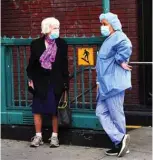  ??  ?? A woman wearing a protective mask speaks to a medical worker from Lenox Hill Hospital during the coronaviru­s pandemic in New York City.