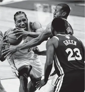  ?? Chris Young / Associated Press ?? Raptors forward Kawhi Leonard, left, draws a foul as he drives to the net against the Warriors’ Andre Iguodala, right, and Draymond Green. The series moves to Oakland for Game 6.