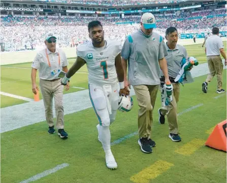  ?? WILFREDO LEE/AP ?? Dolphins quarterbac­k Tua Tagovailoa is assisted off the field after he was injured against the Bills on Sunday in Miami Gardens.