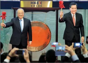 ?? AP/VINCENT YU ?? Hong Kong Exchanges and Clearing Ltd. Chairman Chow Chung-kong (left) and Hong Kong Chief Executive Leung Chun-ying smile after banging a gong during a ceremony to open the ShenzhenHo­ng Kong Stock Connect in Hong Kong on Monday.