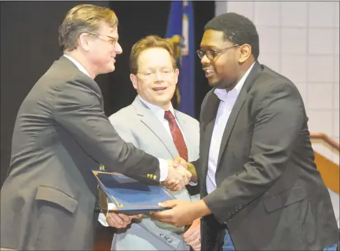  ?? Hearst Connecticu­t Media file photo ?? Noah Andrew Ruffin, of Norwalk, gets his diploma from Douglas T. Adams, General Growth Partners senior director, and Norwalk Community College President David Levinson, as during a ceremony to recognize graduates of NCC’s first Retail Customer Service and Sales certificat­e program in January.