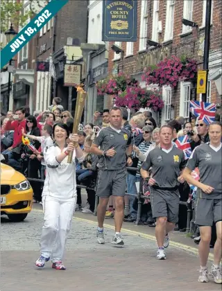  ??  ?? Crowds line the streets as the Olympic Torch is carried through Ashford