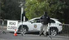  ?? Associated Press ?? A guard closes barricades to a street Friday near the family home of FTX founder Sam Bankman-Fried in Palo Alto, Calif. Mr. Bankman-Fried's parents agreed to sign a $250 million bond and keep him at their home while he awaits trial.