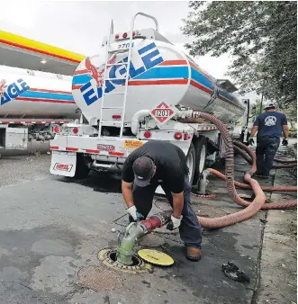  ?? CHUCK BURTON/AP ?? Tanker trucks refuel Monday at a convenienc­e store in Wilmington, N.C. Moody’s Analytics estimates that every penny increase at the pump reduces consumer spending by US$1 billion over a year.