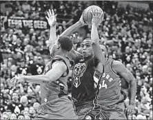  ?? [MORRY GASH/THE ASSOCIATED PRESS] ?? The Milwaukee Bucks’ Khris Middleton drives past the Toronto Raptors’ Kyle Lowry and Norman Powell during the second half on Thursday in Milwaukee.