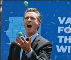  ?? RINGO H.W. CHIU THE ASSOCIATED PRESS ?? California Gov. Gavin Newsom juggles balls with winning numbers after the Vax for the Win lottery contest during a news conference at Universal Studios in Universal City in June 2021.