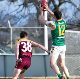  ?? Photograph­s by CRAIG JOHNSON ?? Right: Leongatha’s Steve Forrester marks over Drouin’s Mitchell Diston.