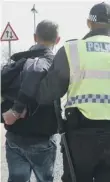  ??  ?? A man is arrested by police officers