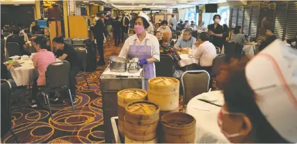  ?? KIN CHEUNG/THE ASSOCIATED PRESS ?? People dine in a restaurant in Hong Kong Thursday, while China's capital, Beijing, remains on high alert for COVID. Authoritie­s there have encouraged people to work from home.