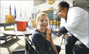  ?? Matthew Brown / Hearst Connecticu­t Media ?? Madeline Marshall of Bedford, N.Y., 9, receives an influenza vaccine from nurse Pauline Pochette during a free clinic in Stamford in January 2018.