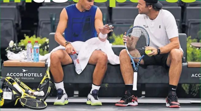  ??  ?? PREPARADO. Rafa Nadal y Carlos Moyá charlan durante un descanso del entrenamie­nto previo al debut del tenista balear en el Masters 1.000 de París.