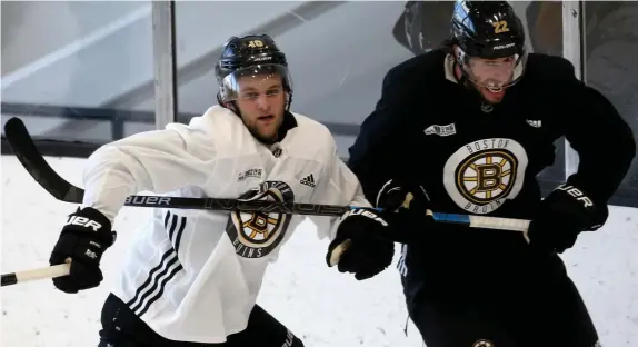  ?? NAncy LAnE / HERALD sTAff fiLE ?? NEW ROLE: Bruins left wing Anders Bjork, left, tangles with Craig Smith behind the net during training camp at Warrior Ice Arena on Jan. 7.