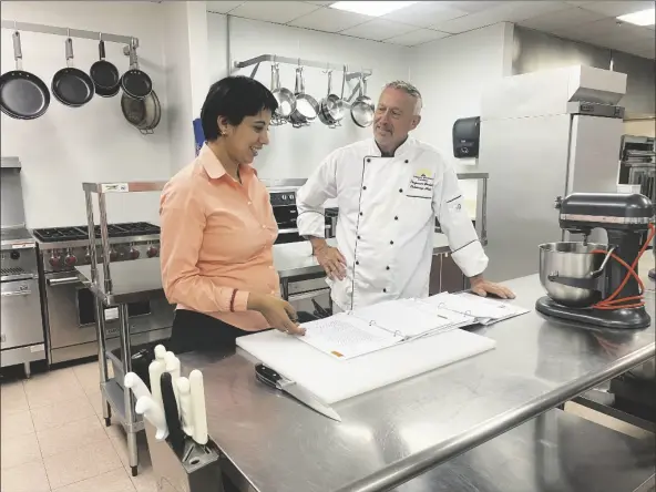  ?? PHOTOS BY MARA KNAUB/YUMA SUN ?? REETIKA DHAWAN (LEFT), VICE PRESIDENT OF WORKFORCE DEVELOPMEN­T the upcoming restaurant boot camp in the commercial kitchen at AWC. at Arizona Western College, consults with Bob Gedeon, professor of culinary arts, on