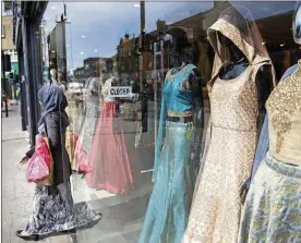  ?? AP PHOTO / TIM IRELAND ?? A person shops at Upton Park in London on May 22. “Mainstream fashion is now talking about modest fashion as a thing. Ten years ago, if you were a brand coming from a religious background and tried to sell it in department stores, calling it a modest...